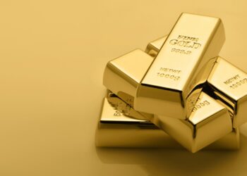 A stack of gold bars arranged in an interlocking manner against a gold-colored background. Each bar is labeled "FINE GOLD" with a weight of 1000 grams (NET WT 1000G) and a purity of 999.9, encouraging you to invest in gold. | LESSINVEST