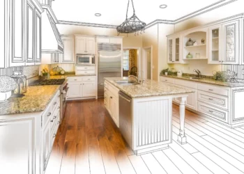 A hybrid image of a kitchen showcases a modern design with granite countertops, white cabinets, and stainless steel appliances. The right half is a detailed sketch, blending seamlessly into the realistic left half with a central island and pendant lighting—a perfect inspiration for those looking to invest in real estate. | LESSINVEST