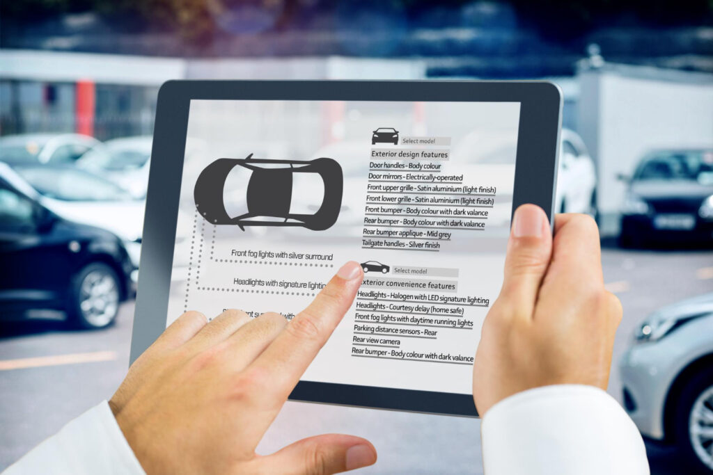 A person holding a tablet displaying a car design Vehicle History Report interface with various options and features listed important when you Buying a Car . The background shows a parking lot with several parked cars. | LESSINVEST
