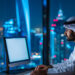 A man in traditional Middle Eastern attire works on a computer in a modern office with large windows overlooking a city skyline, highlighting how financial literacy matters in the UAE’s digital gambling age. | LESSINVEST