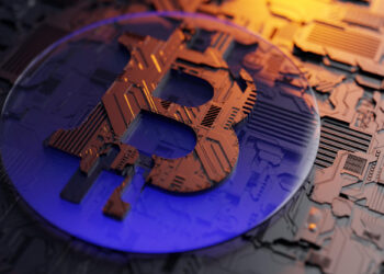 A close-up of a metallic Bitcoin symbol embedded in a digital circuit board, with blue and orange lighting reflecting on the surface, representing cryptocurrency, blockchain technology, and exploring how casino Bitcoins work. | LESSINVEST