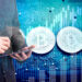 A person in a suit writes on a tablet, with digital graphics of two Bitcoin symbols and abstract financial and circuit patterns in the background. | LESSINVEST