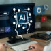 A person using a desktop computer displaying AI-related graphics, including icons of gears, speech bubbles, and a human profile connected to the letters "AI." A notepad, pen, calculator, and keyboard are on the desk. | LESSINVEST